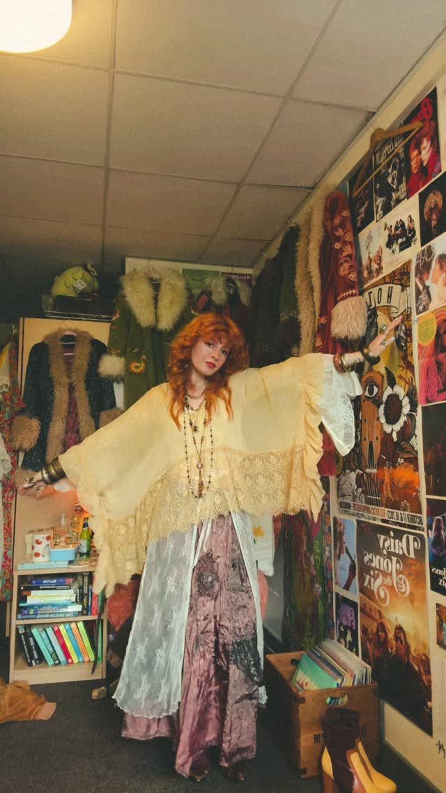 70s Inspired Outfits with 22 Groovy Looks to Try Now 13 Woman with red hair wearing a yellow lace shawl and long patterned skirt.