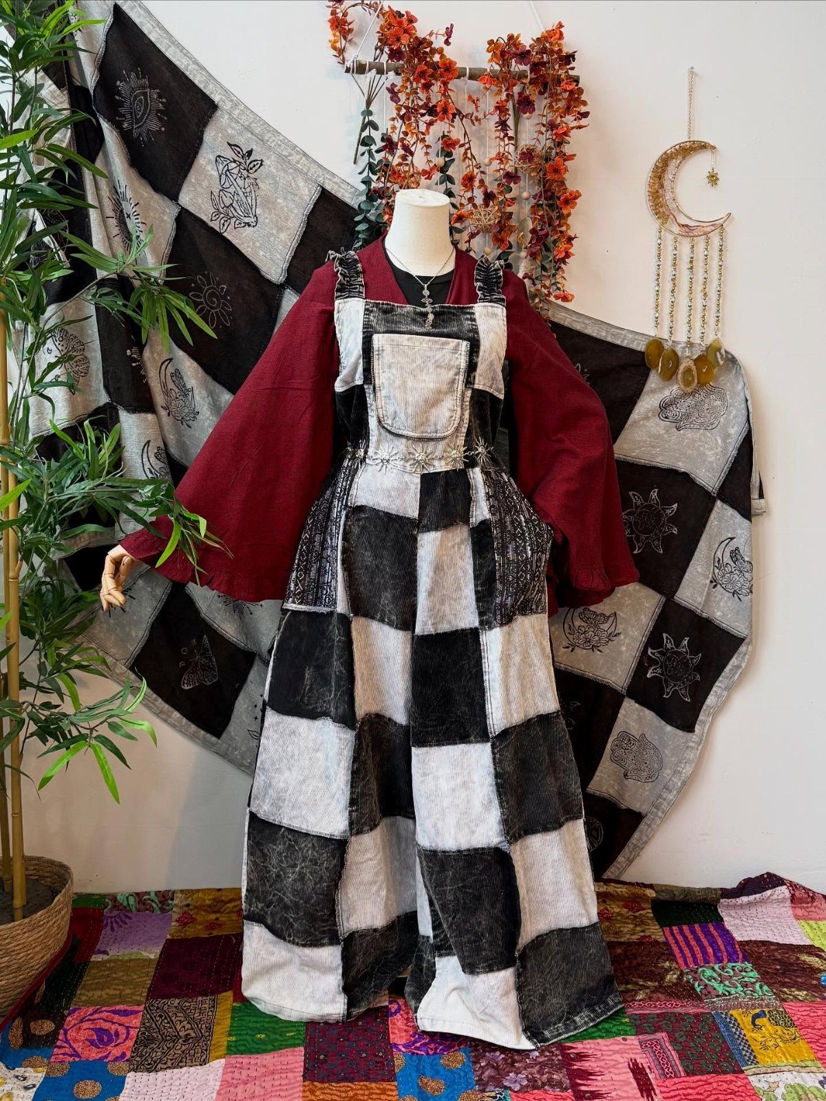 70s Inspired Outfits with 22 Groovy Looks to Try Now 20 Mannequin wearing a black and white checkered jumper dress over a maroon long-sleeved blouse.