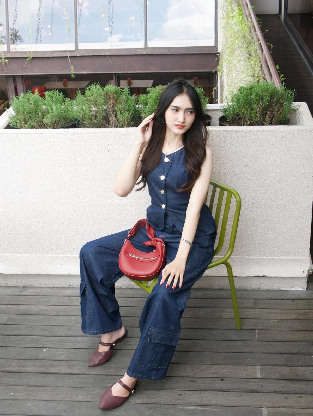 Woman in a dark blue denim sleeveless top and matching wide-leg denim trousers.