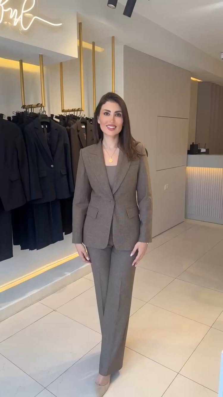 5 All Brown Outfit Ideas to Refresh Your Wardrobe 4 Woman wearing a matching brown tailored suit set in a clothing store.