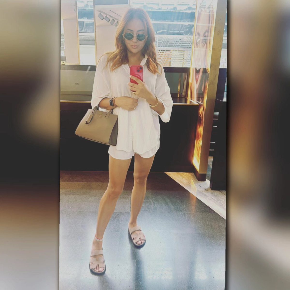 Beach Vacation Outfits: 9 Ideas for Easy Packing 9 Woman in a white romper and sandals posing with a handbag and smartphone.
