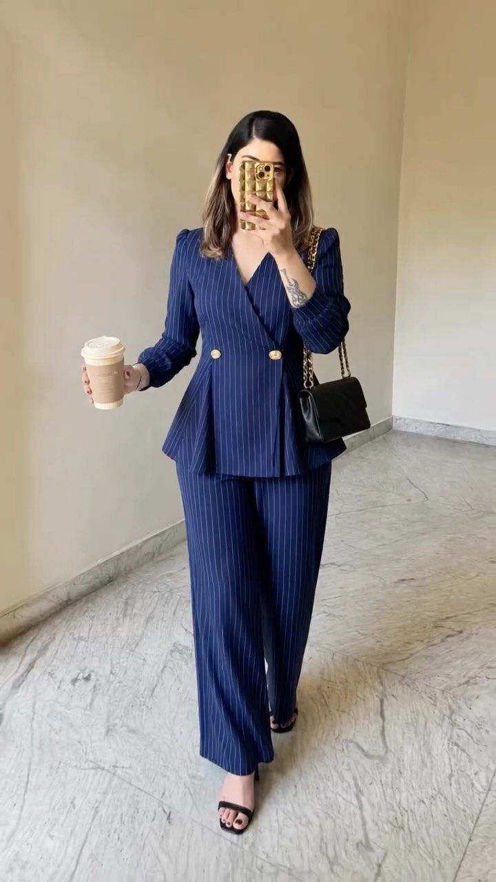 Business Casual Outfits for Work: 8 Polished Ideas 4 Woman wearing a navy blue pinstriped blazer and matching wide-leg trousers set.