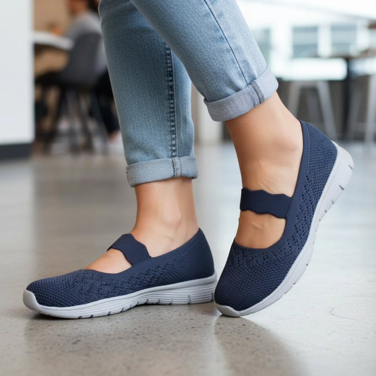 Navy blue mesh walking shoes worn with cuffed light blue denim jeans.