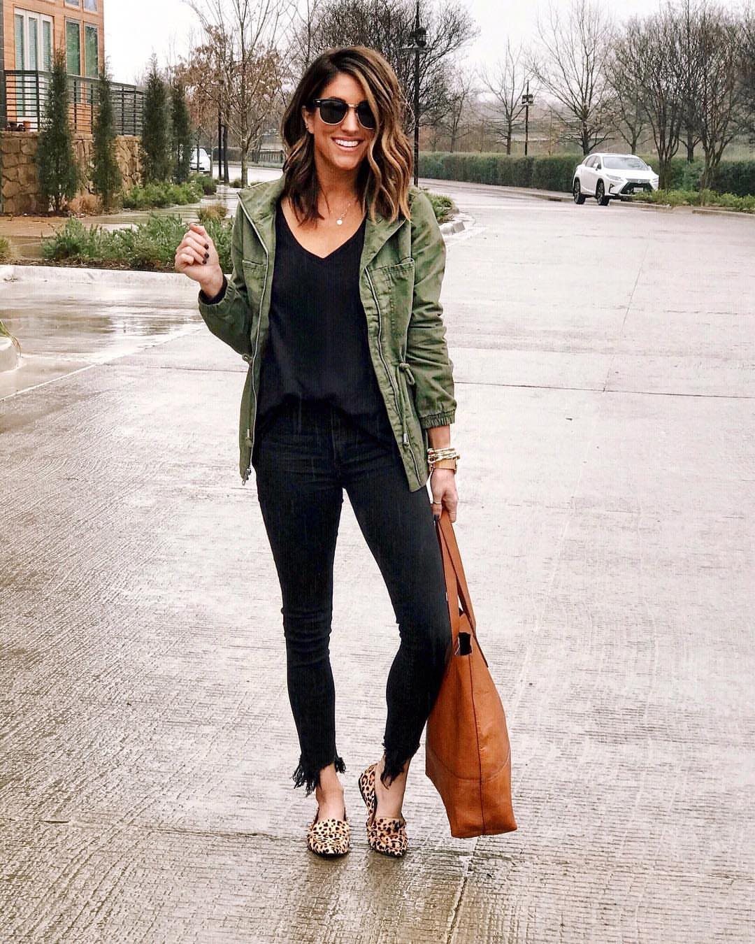 Woman wearing olive green utility jacket, black jeans, and leopard print flats.
