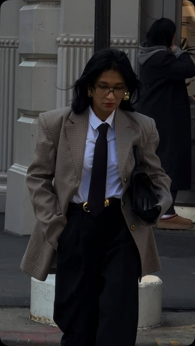 Casual Street Style: 8 Outfit Ideas for Women 4 Woman in oversized plaid blazer, white shirt, black tie, and black trousers.