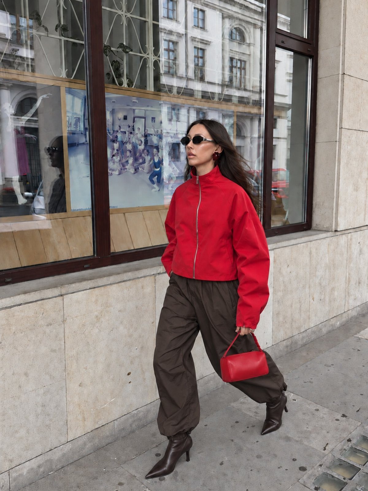 Casual Street Style: 8 Outfit Ideas for Women 7 Woman wearing a bright red jacket and brown cargo pants on a city street.