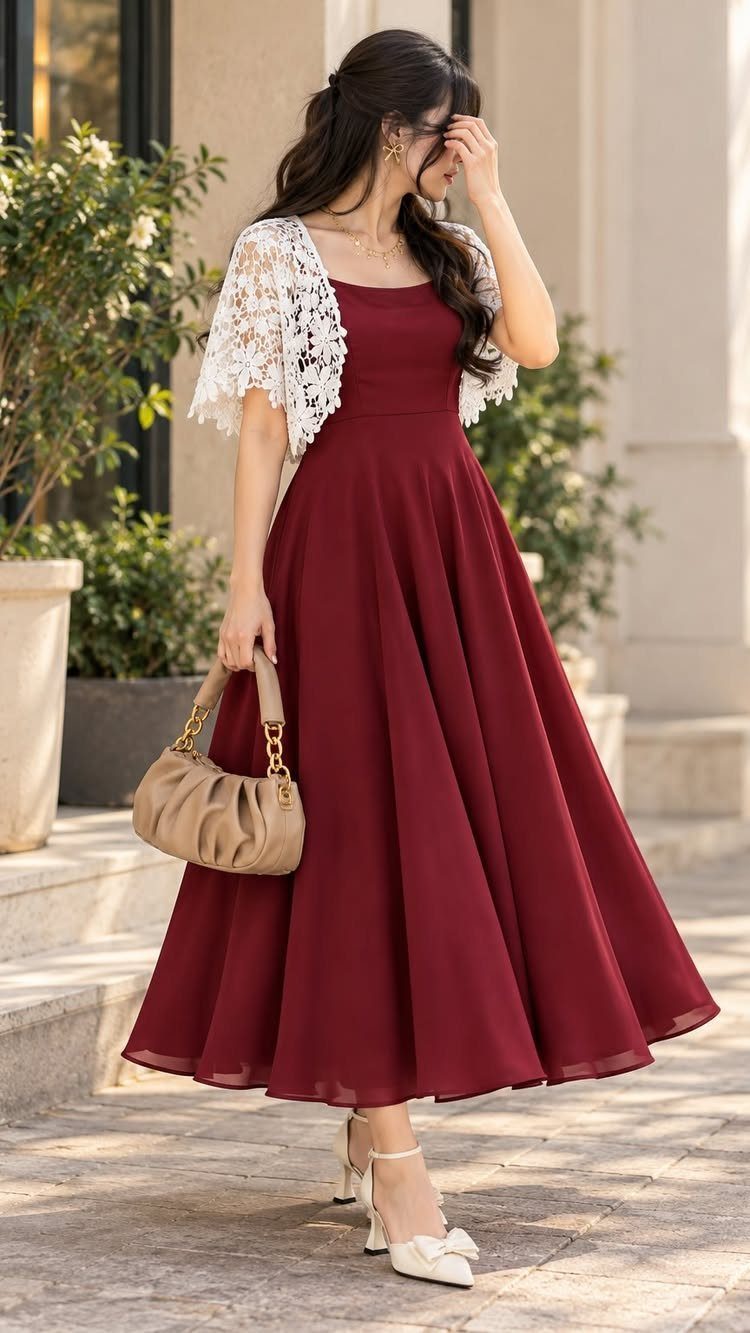 26 Classy Date Outfits From Casual to Elegant 21 Woman in a burgundy flared dress and white lace shrug holding a beige handbag.