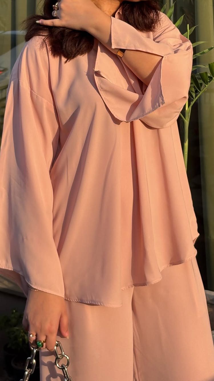 26 Classy Date Outfits From Casual to Elegant 16 Person wearing a dusty rose pink matching two-piece set with a flowing blouse.