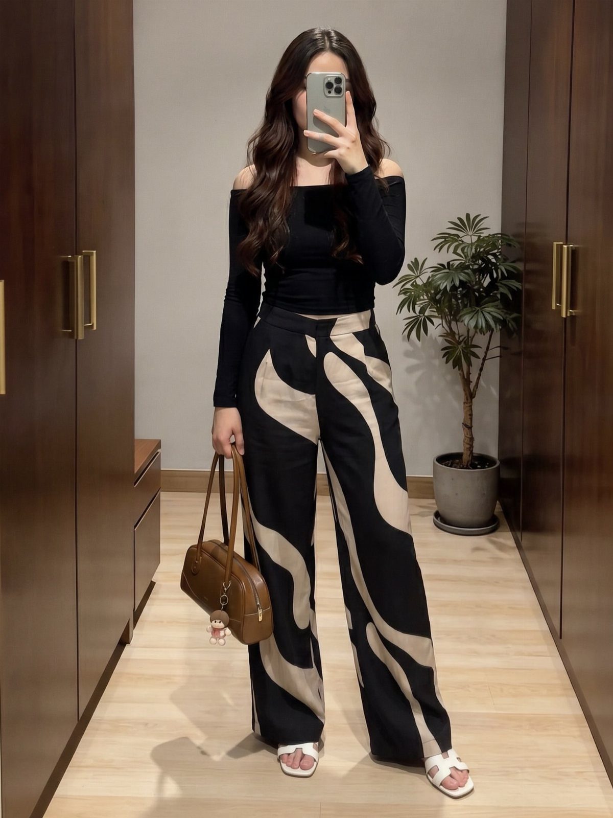 26 Classy Date Outfits From Casual to Elegant 15 Woman wearing patterned wide-leg pants and a simple black off-the-shoulder top.