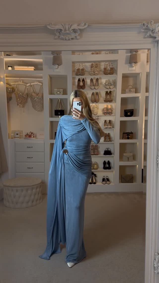 26 Classy Date Outfits From Casual to Elegant 20 Woman in a long blue draped gown posing in a white walk-in closet.