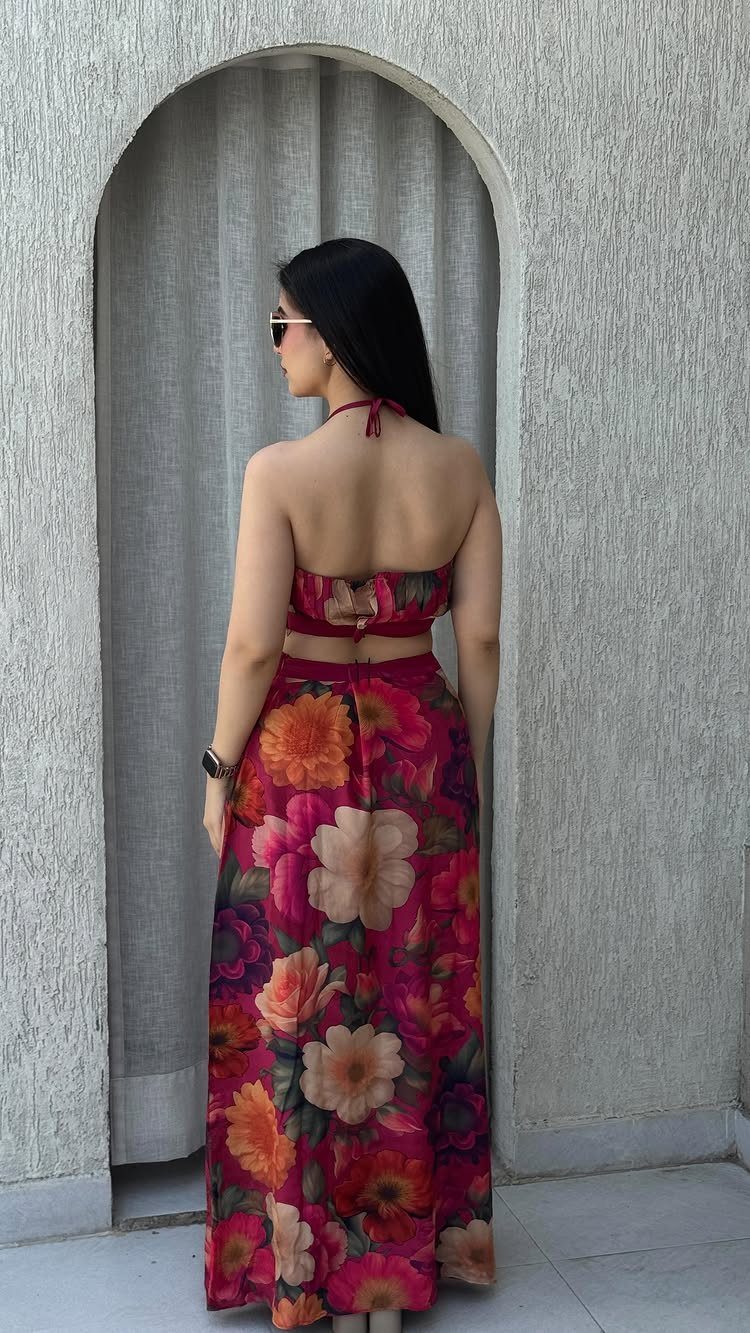 Woman wearing a red and orange floral print matching crop top and maxi skirt.