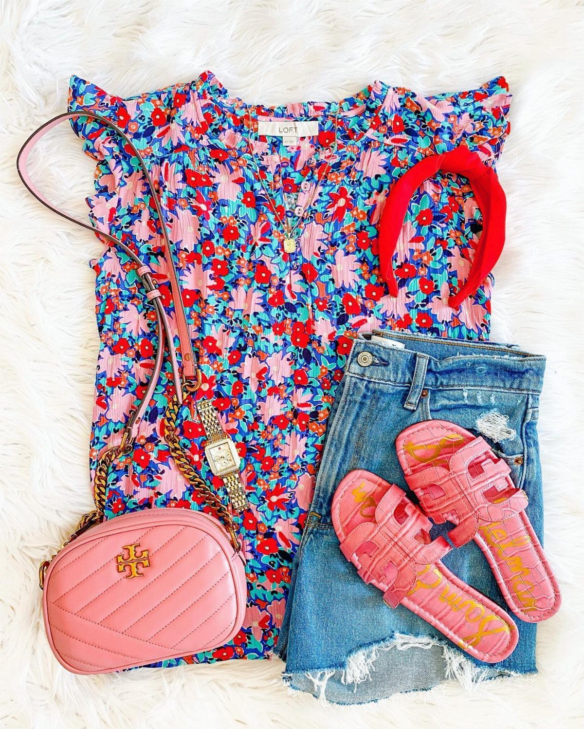 Floral blouse, denim shorts, pink crossbody bag, and pink sandals on white fur.