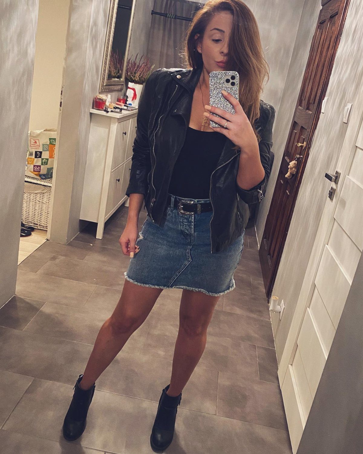 Denim Skirt Outfits: 19 Ways to Style Them This Season 2 Woman wearing a leather jacket, denim mini skirt, and black ankle boots.