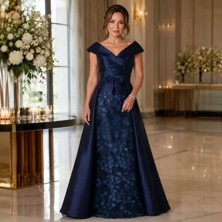 Woman in a navy blue off-the-shoulder gown with floral lace center panel