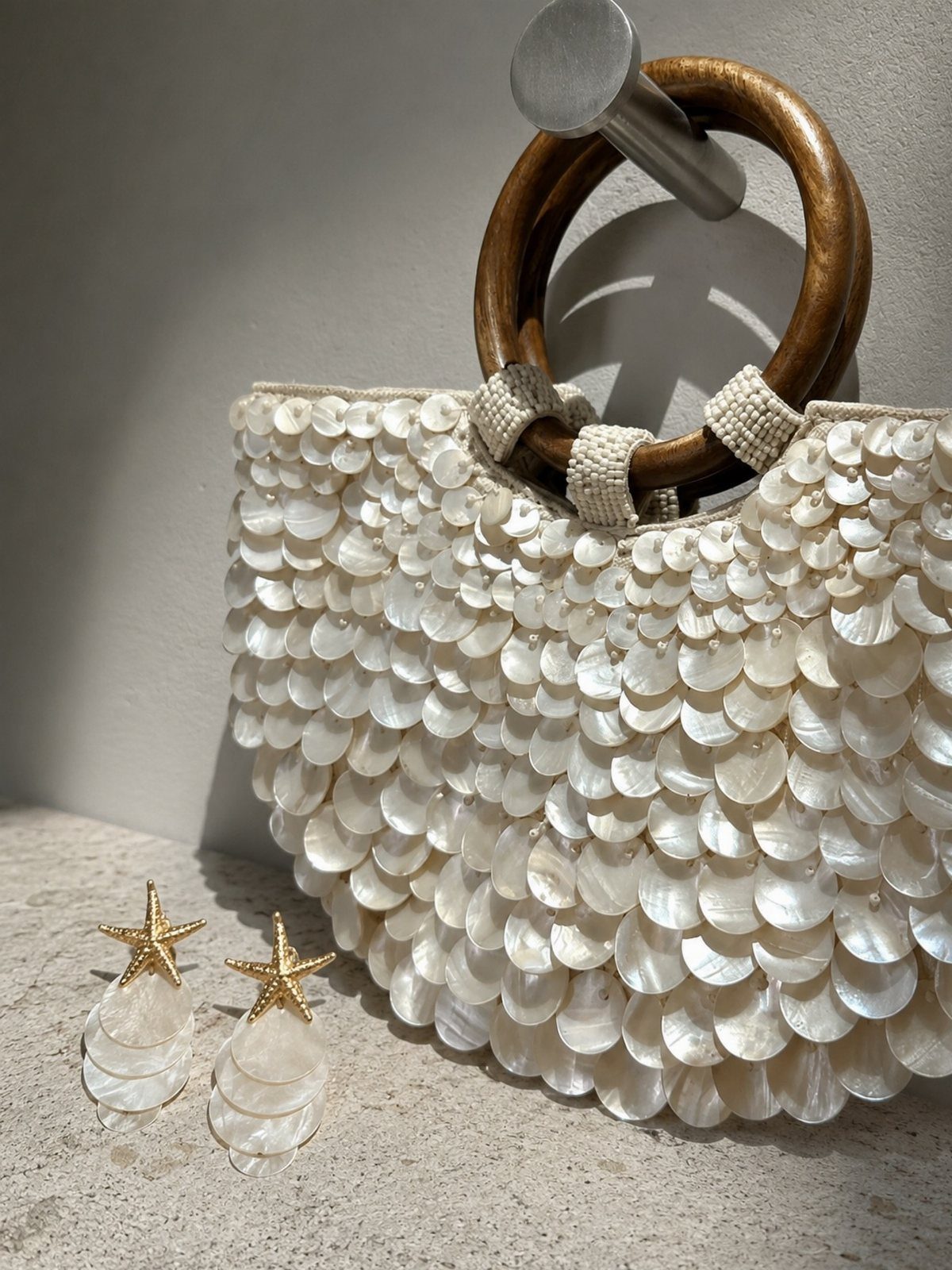 Fall Beach Outfits: 20 Ideas for Your Coastal Getaway 12 White shell-sequined evening bag with wooden handles and gold starfish earrings.