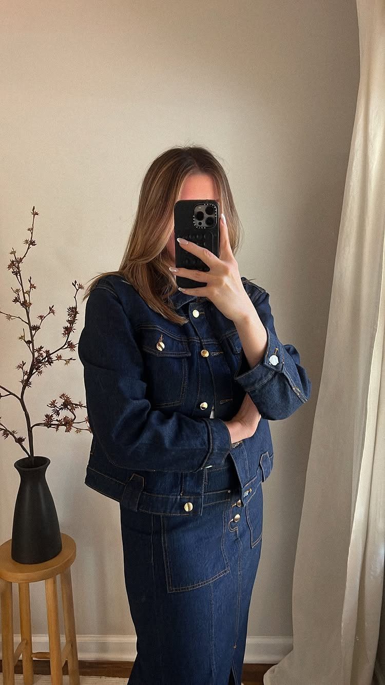 Woman wearing a coordinated dark denim jacket and matching long denim skirt.