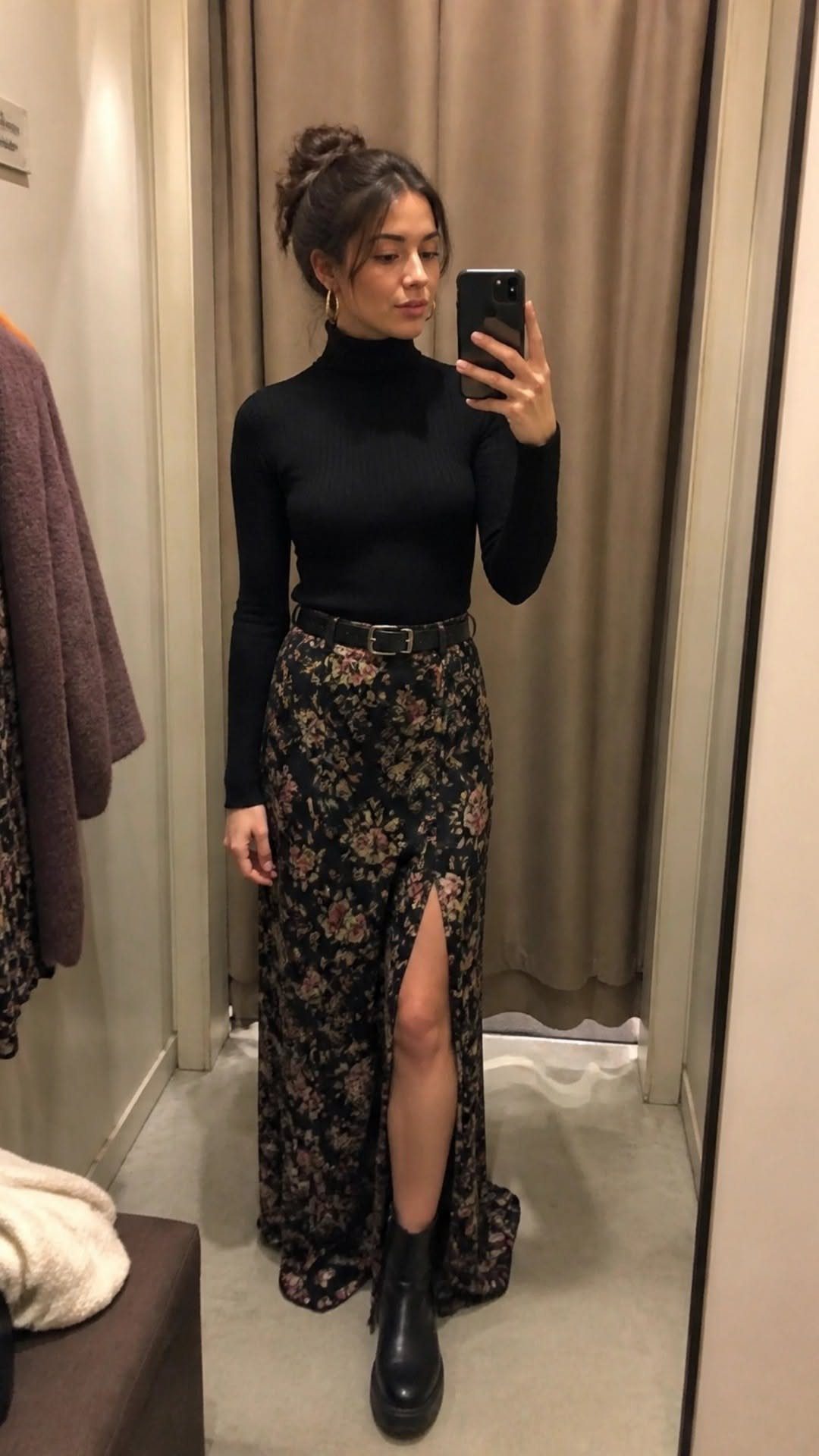 Woman wearing a black turtleneck and a high-waisted black floral maxi skirt.