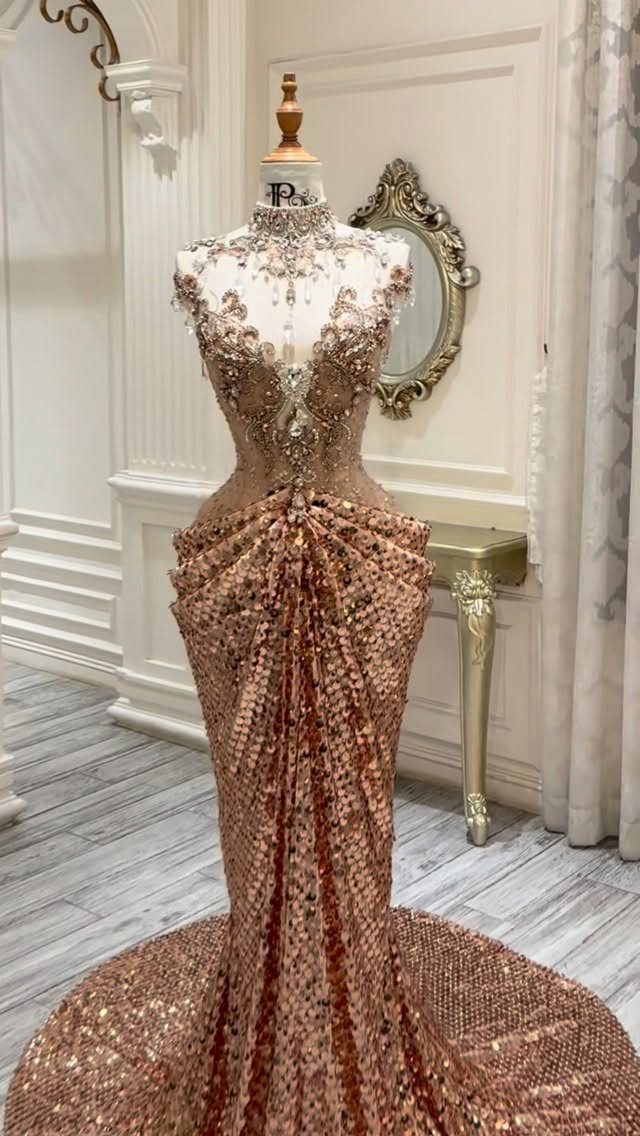 Gold sequined mermaid gown with an embellished sheer bodice displayed on a mannequin.