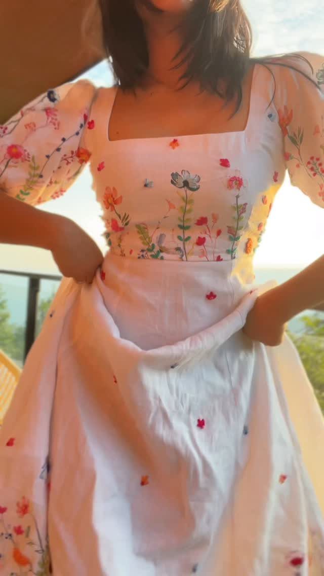 Linen Fashion Women: 6 Outfit Upgrades for 2026 1 Woman wearing a white linen dress with colorful floral embroidery and puffed sleeves.