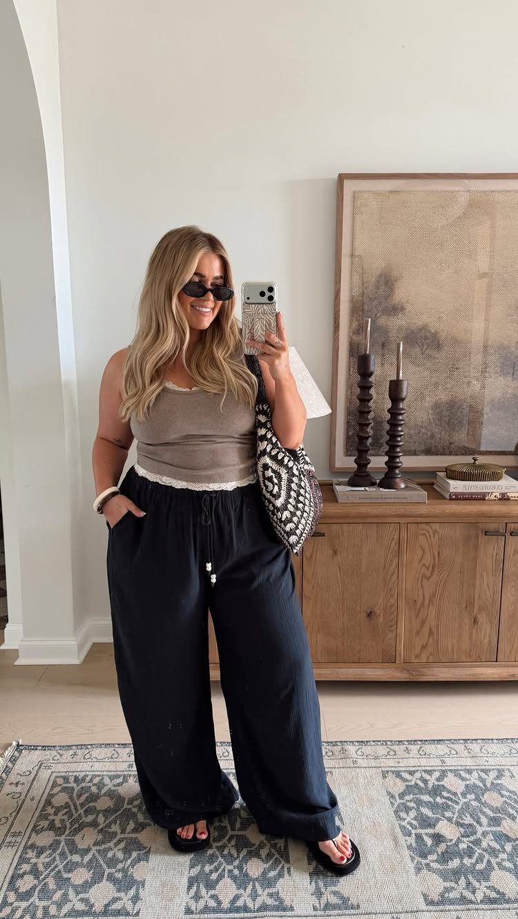 Woman wearing a taupe tank top and wide-leg black linen pants for summer.