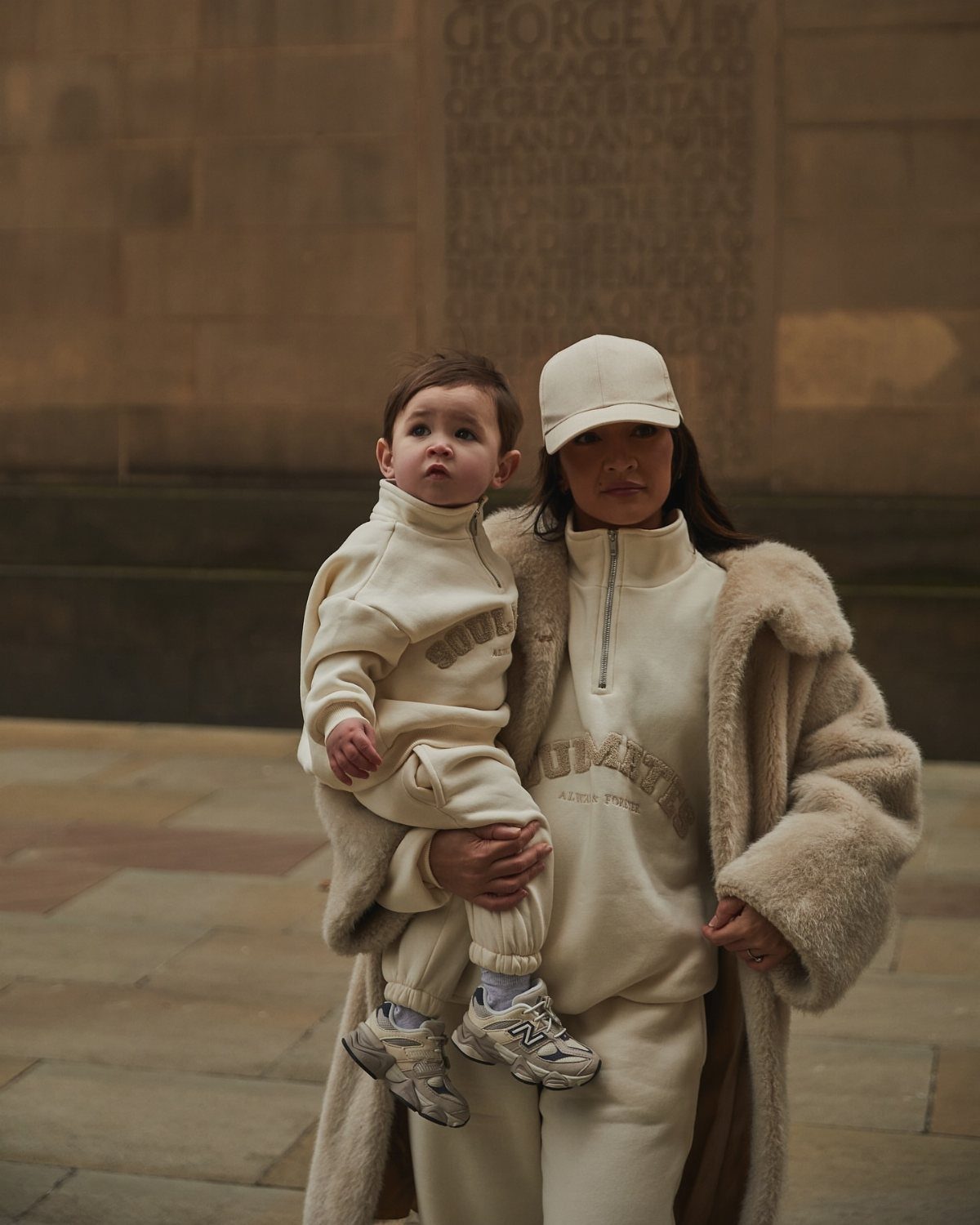 10 Outfit Ideas for Mom: From Classic Days to Mom's Nights Out 7 Woman and toddler wearing matching cream-colored loungewear sets and a large beige faux fur coat.
