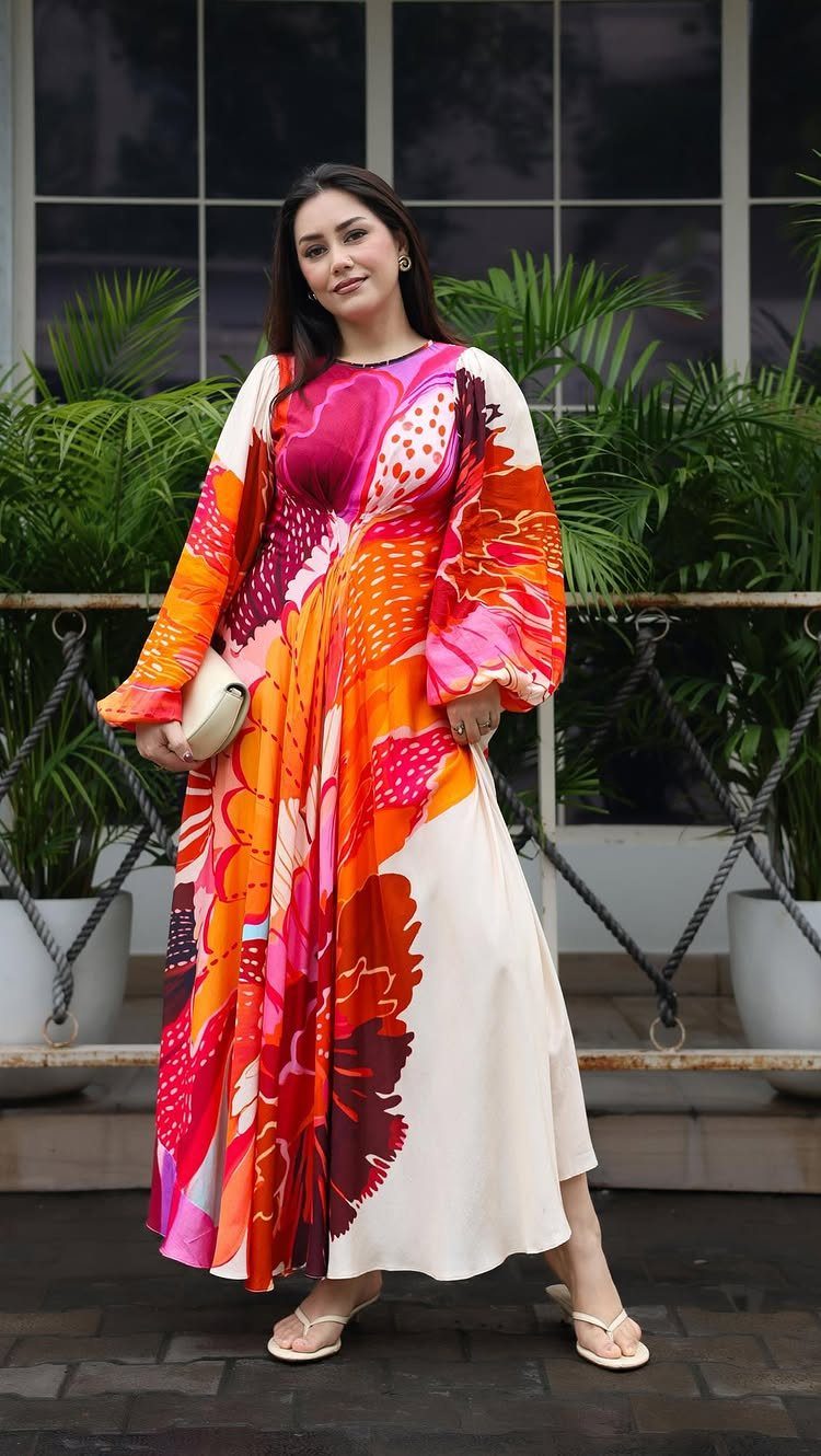 Outfit Ideas for Cancun: 13 Looks for Every Occasion 1 Woman in a colorful floral maxi dress holding a white clutch outdoors.