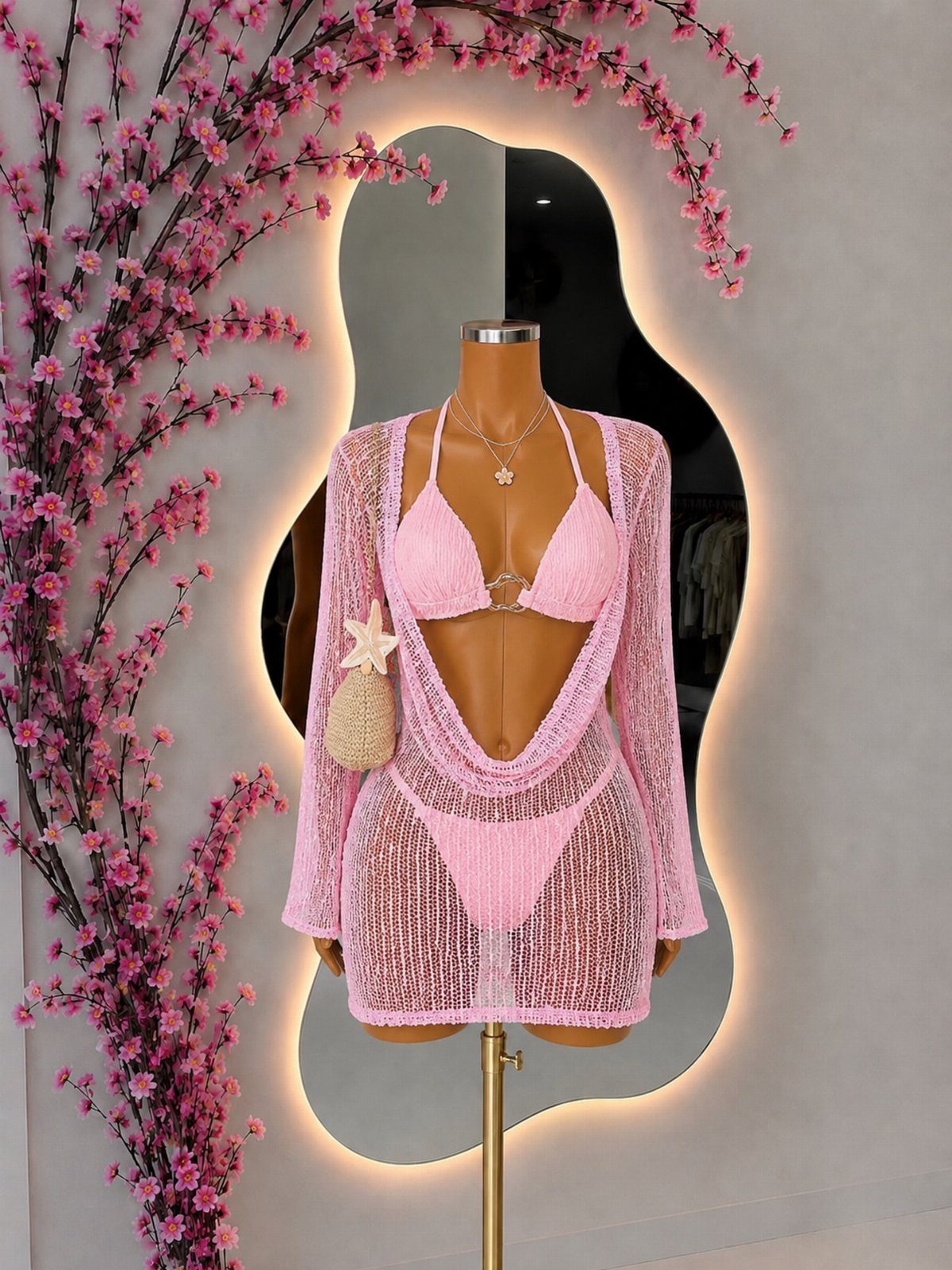 Outfit Ideas for Cancun: 13 Looks for Every Occasion 7 Pink bikini and sheer crochet cover-up displayed on a mannequin with pink flowers.