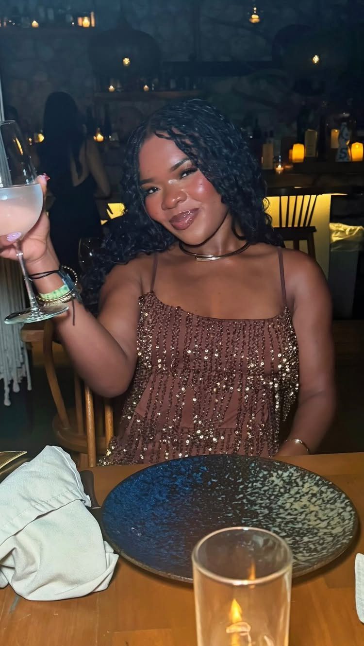 Outfit Ideas for Cancun: 13 Looks for Every Occasion 6 Woman wearing a brown sparkly sequined minidress holding a glass of champagne.