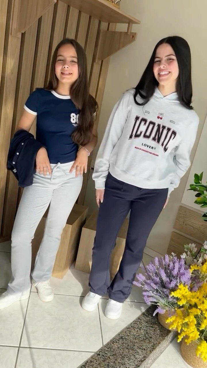 11 Outfits for Teens: Street to Semiformal Style Ideas 11 Two teenage girls posing in casual outfits with hoodies, t-shirts, and wide-leg pants.