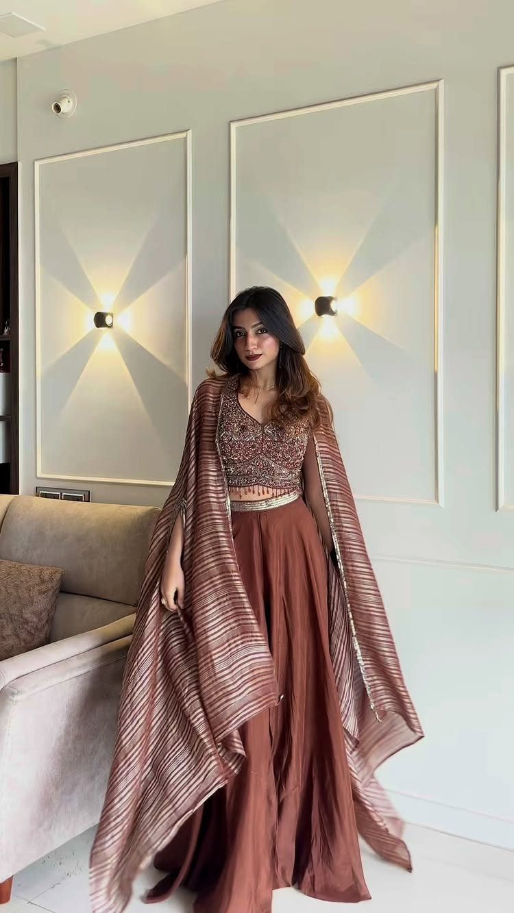 11 Outfits for Teens: Street to Semiformal Style Ideas 5 Woman posing in an embellished brown crop top, wide-leg pants, and a long striped cape.