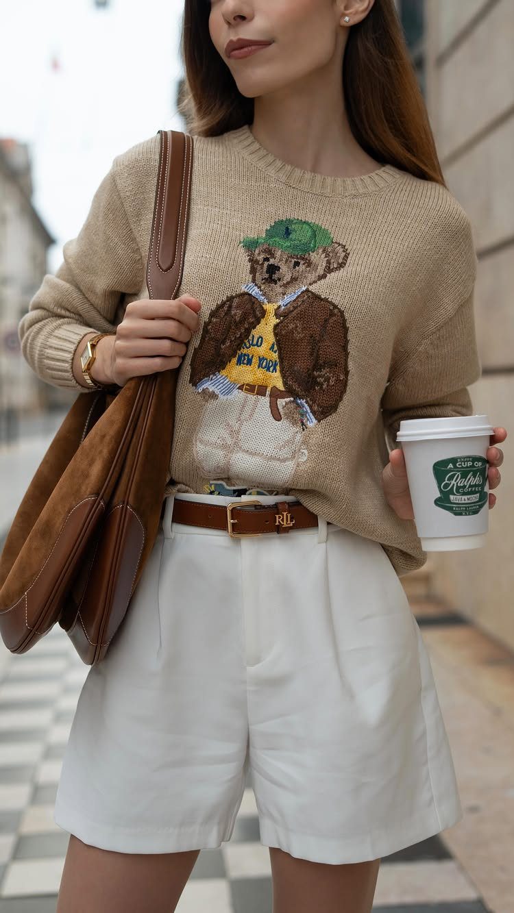 Woman wearing a tan Polo Bear sweater and high-waisted white shorts outdoors.
