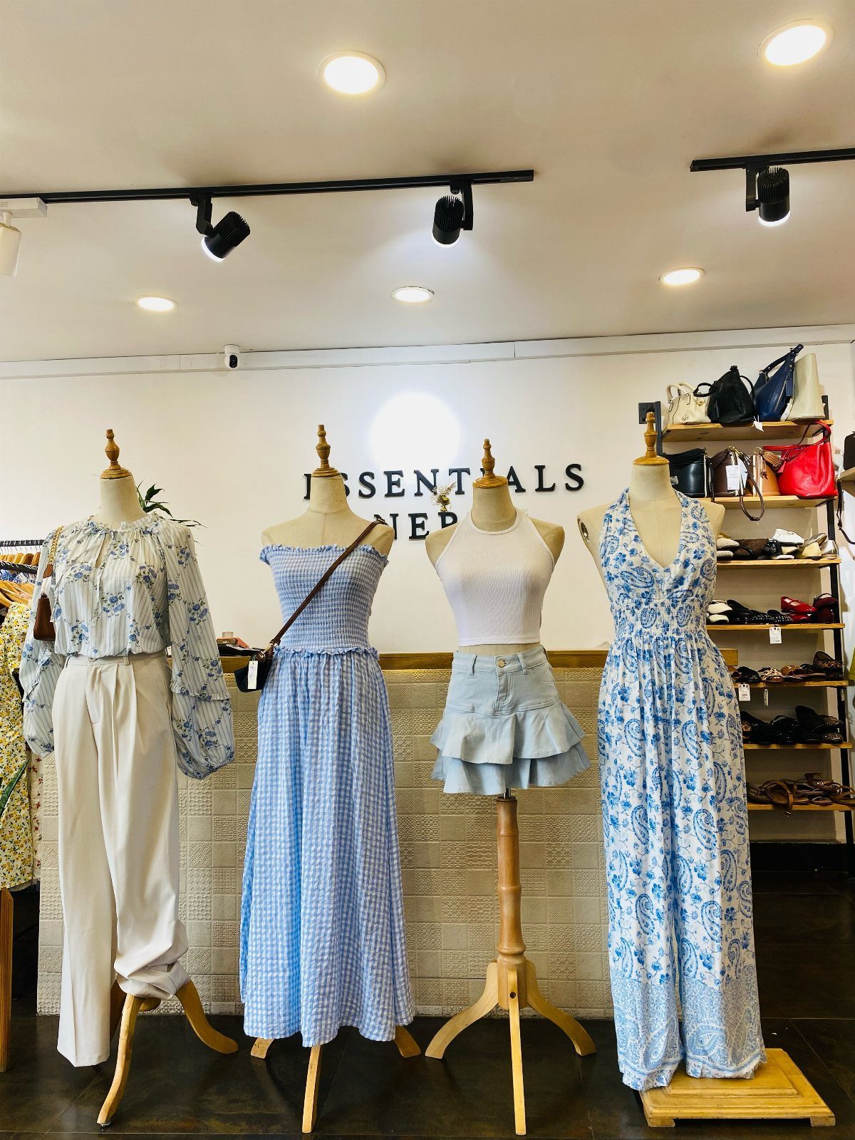 11 Spring Summer Outfits You'll Reach for All Season Long 11 Four mannequins displaying various blue and white spring outfits in a bright clothing store.