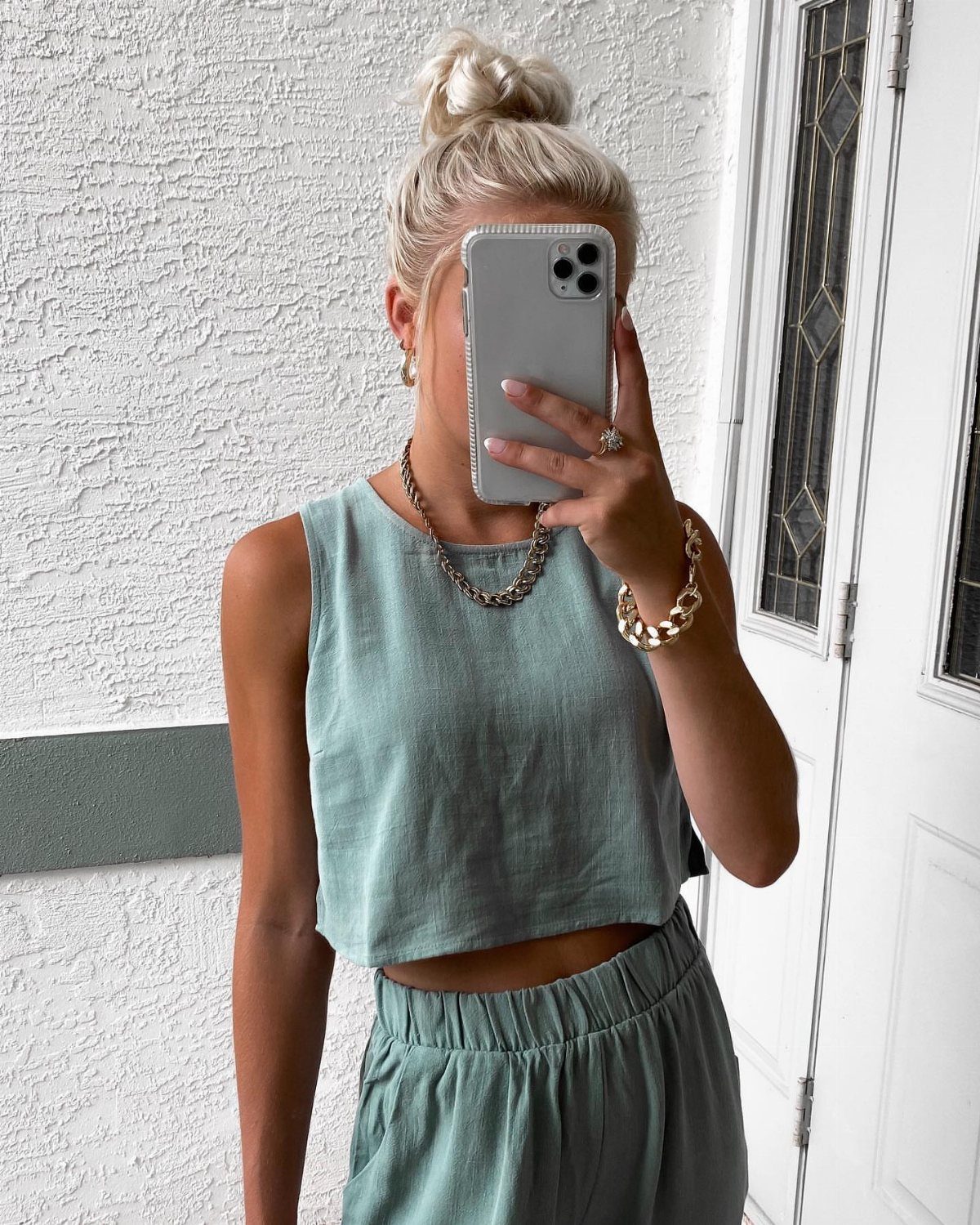 Woman wearing a sage green linen cropped top and matching drawstring trousers.