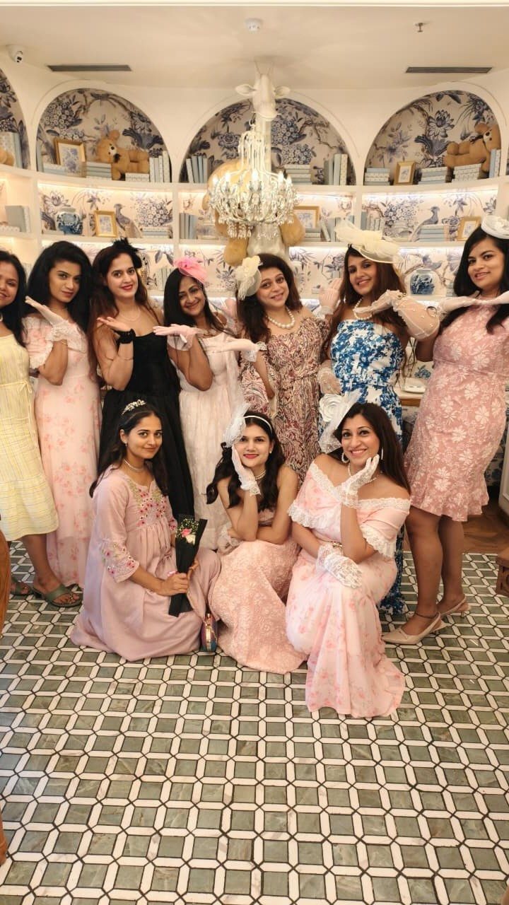 Tea Party Dresses: 6 Outfit Ideas for Brunches and Garden Events 3 Group of women posing in elegant pastel dresses and accessories in a decorated room.