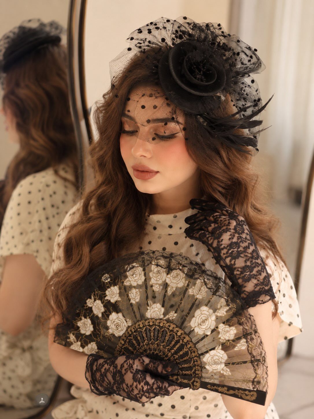 12 Tea Party Outfit Ideas for Women: Dresses, Hats & Accessories 8 Woman wearing black lace gloves and holding a decorative lace fan while wearing a floral headpiece.