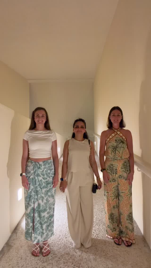 Three women posing in a hallway wearing elegant summer resort outfits.