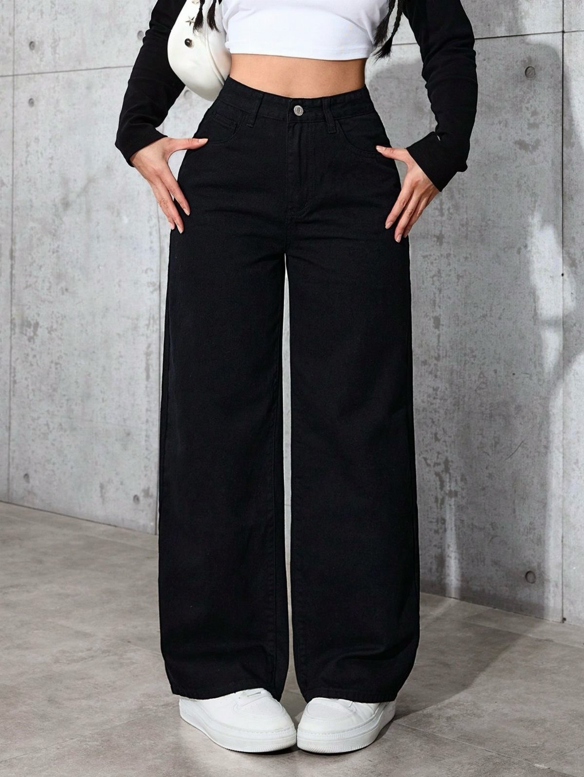 12 Wide Leg Pants Outfit Ideas, From Casual to Polished 3 Person wearing a white cropped top and black wide-leg denim pants with white sneakers.