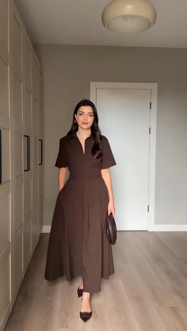 Women's Business Casual: 10 Outfit Ideas for the Office 9 Woman in a brown midi dress and heels standing in a hallway near white cabinets.
