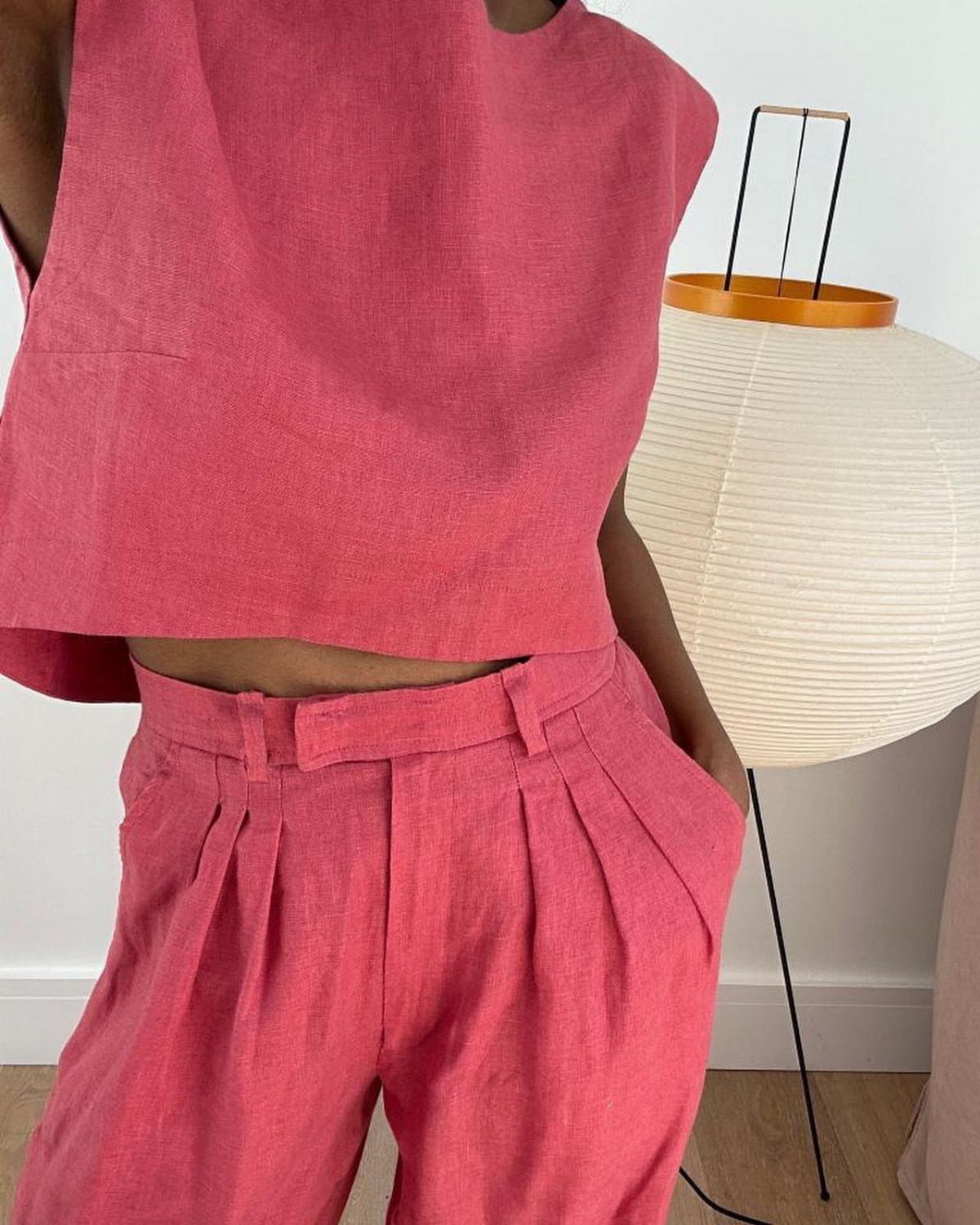 Pink linen cropped top and matching pleated relaxed trousers worn by a person.
