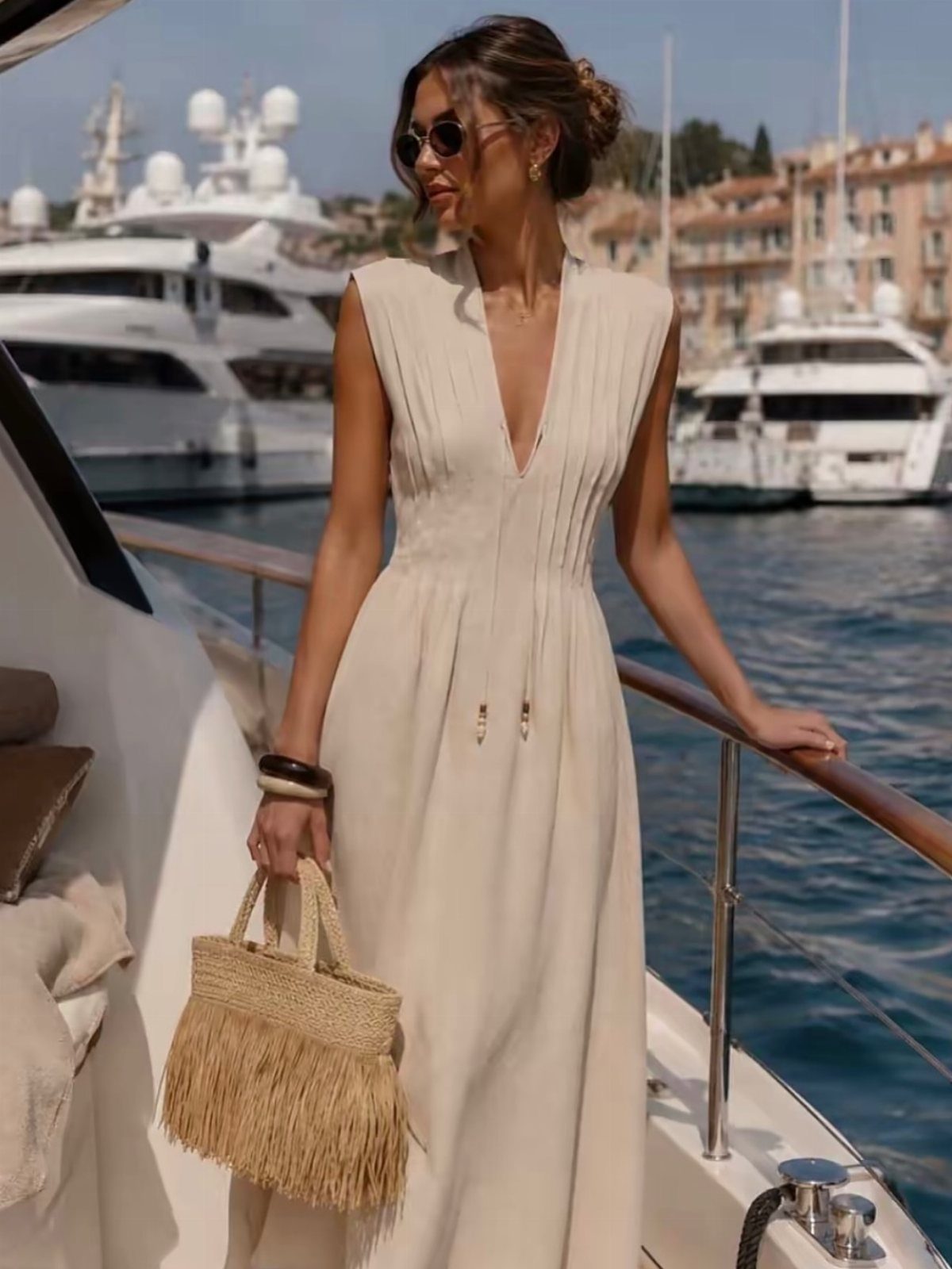 Zara Summer Dresses From Mini to Maxi (21 Characters) 16 Woman in a cream sleeveless maxi dress holding a straw bag on a yacht.