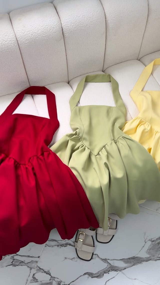 Zara Summer Dresses From Mini to Maxi (21 Characters) 19 Three colorful halter mini dresses in red, green, and yellow on a white sofa.