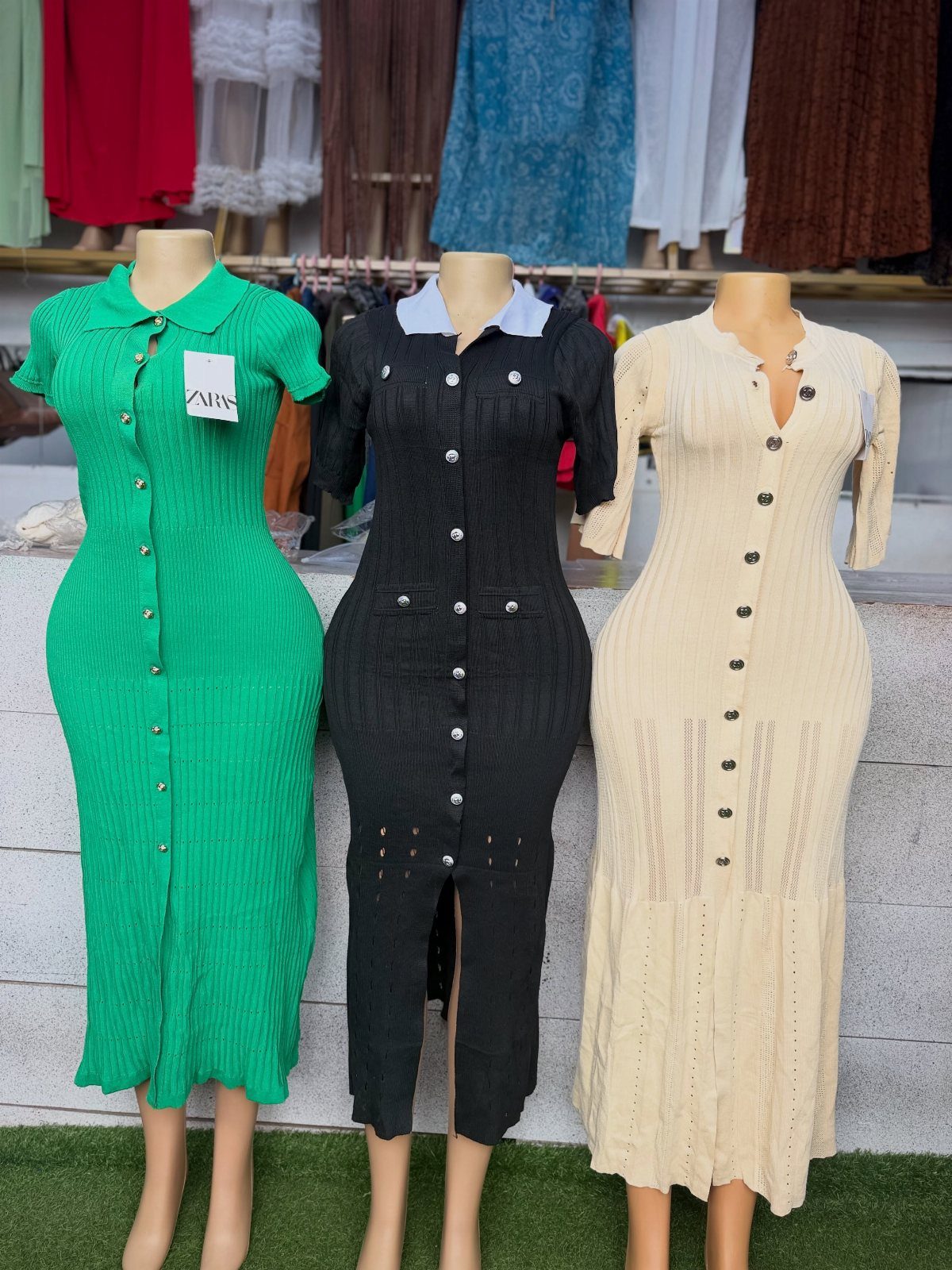 Zara Summer Dresses From Mini to Maxi (21 Characters) 12 Three knit bodycon dresses with buttons in green, black, and cream on mannequins.