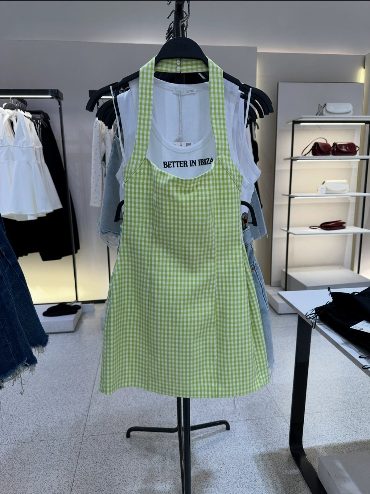 Zara Summer Dresses From Mini to Maxi (21 Characters) 20 Lime green gingham halter mini dress hanging on a rack in a store.