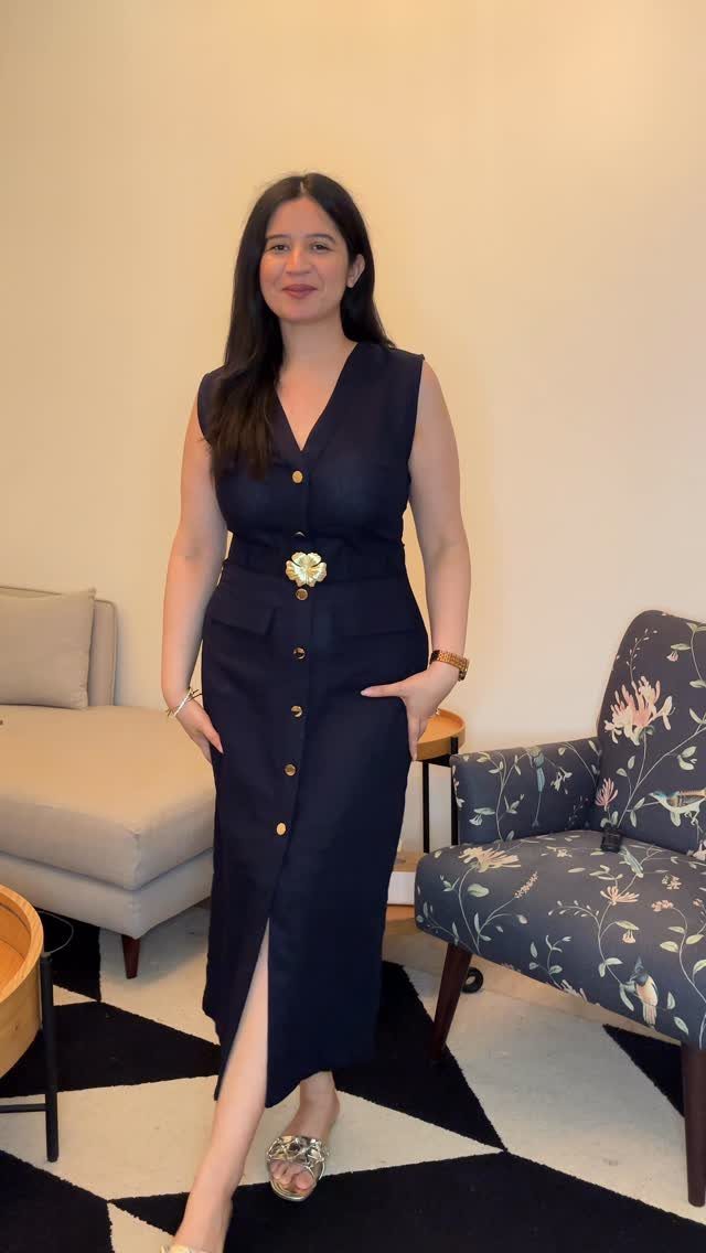 Zara Summer Dresses From Mini to Maxi (21 Characters) 13 Woman in a navy blue sleeveless midi dress with gold buttons and belted waist.