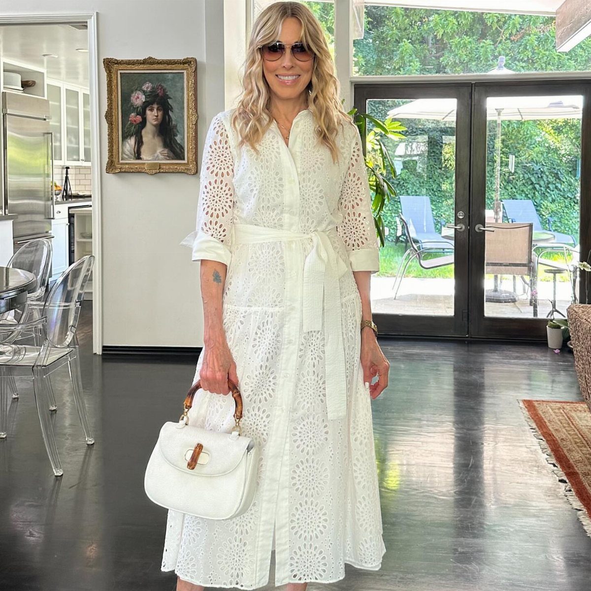 Zara Summer Dresses From Mini to Maxi (21 Characters) 6 Woman wearing a white eyelet lace midi dress with a matching white handbag.